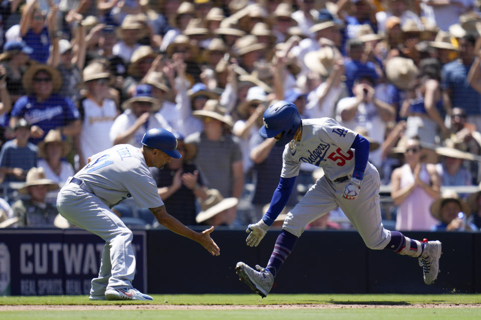 Los Angeles Dodgers' Mookie Betts, right, celebrates with third base coach Dino Ebel after hitting a grand slam during the fourth inning of a baseball game against the San Diego Padres, Monday, Aug. 7, 2023, in San Diego. (AP Photo/Gregory Bull)