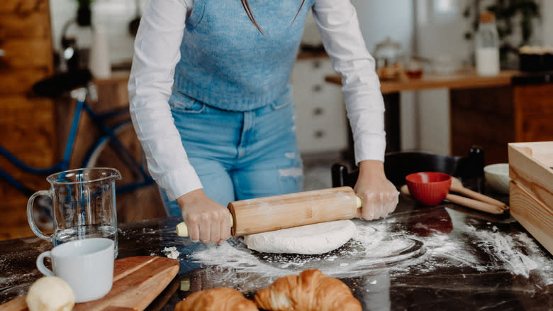 Woman rolls out dough 