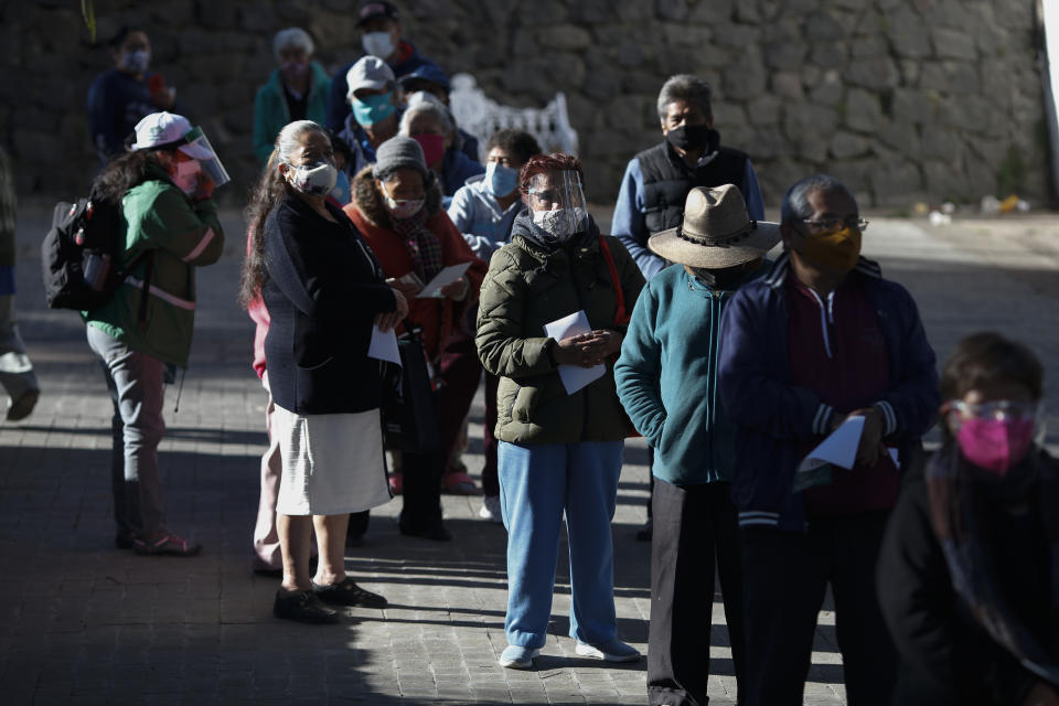 Personas mayores de 60 años esperan recibir la vacuna AstraZeneca para COVID-19 en una jornada en que México comienza a inmunizar a su población anciana contra el nuevo coronavirus en el distrito periférico de Milpa Alta de la Ciudad de México, el lunes 15 de febrero de 2021. (AP Foto/ Rebecca Blackwell)