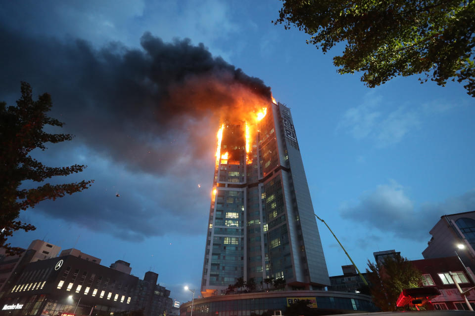 An apartment building is engulfed in a fire in Ulsan, South Korea, Friday, Oct. 9, 2020. A fire spread through the high-rise apartment building in the port city early Friday, causing minor injuries to scores of people, officials said. (Kim Yong-tae/Yonhap via AP)