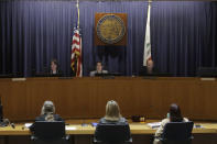 California Public Utilities Commissioners Genevieve Shiroma, from top left, Liane Randolph and Cliff Rechtschaffen speak after voting at a CPUC meeting in San Francisco, Wednesday, Nov. 13, 2019. California regulators will vote Wednesday on whether to open an investigation into pre-emptive power outages that blacked out large parts of the state for much of October as strong winds sparked fears of wildfires. (AP Photo/Jeff Chiu)