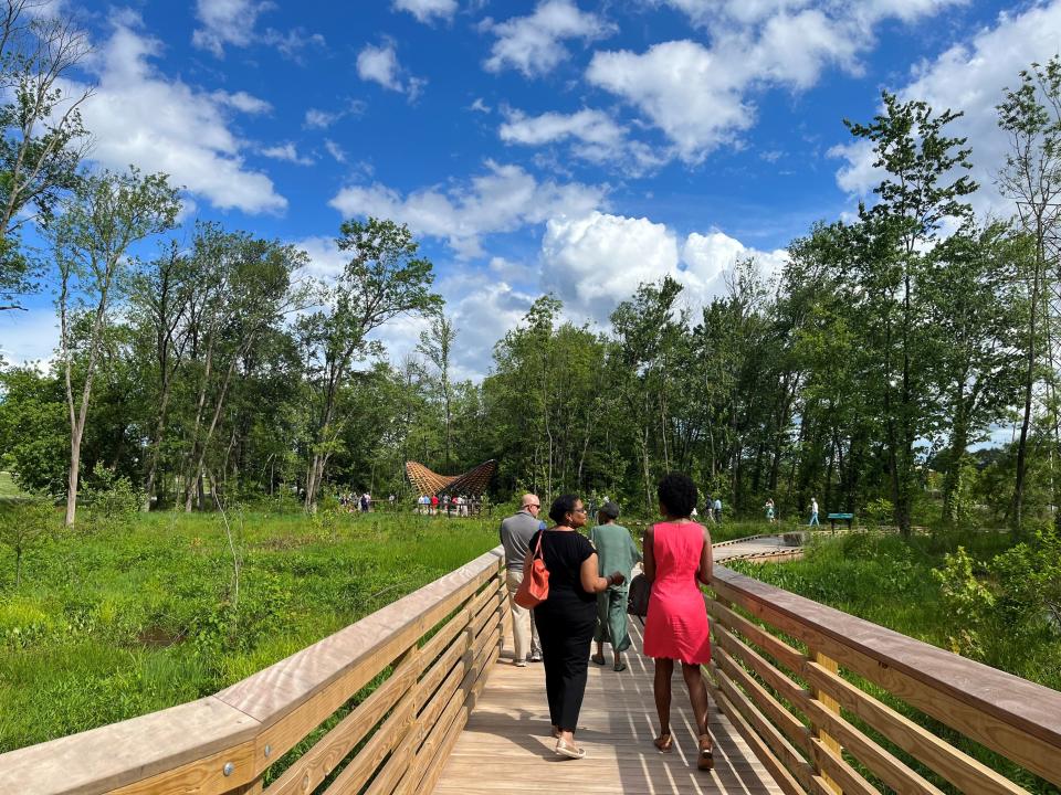 People walk on the new boardwalk system in Unity Park's Reedy River Wetlands Nature Preserve that opened May 17.