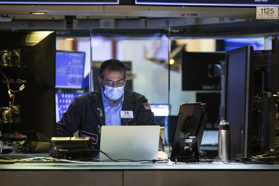 In this photo provided by the New York Stock Exchange, trader Aman Patel wears a protective face mask as he works on the partially reopened trading floor, Tuesday, May 26, 2020. Stocks surged on Wall Street in afternoon trading Tuesday, driving the S&P 500 to its highest level in nearly three months, as hopes for economic recovery overshadow worries about the coronavirus pandemic. (Colin Zimmer/New York Stock Exchange via AP)