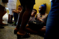 Children play with a mobile phone during a religious ceremony where victims of the Boeing 737 plane crash were remembered in Havana, Cuba, May 20, 2018. REUTERS/Alexandre Meneghini