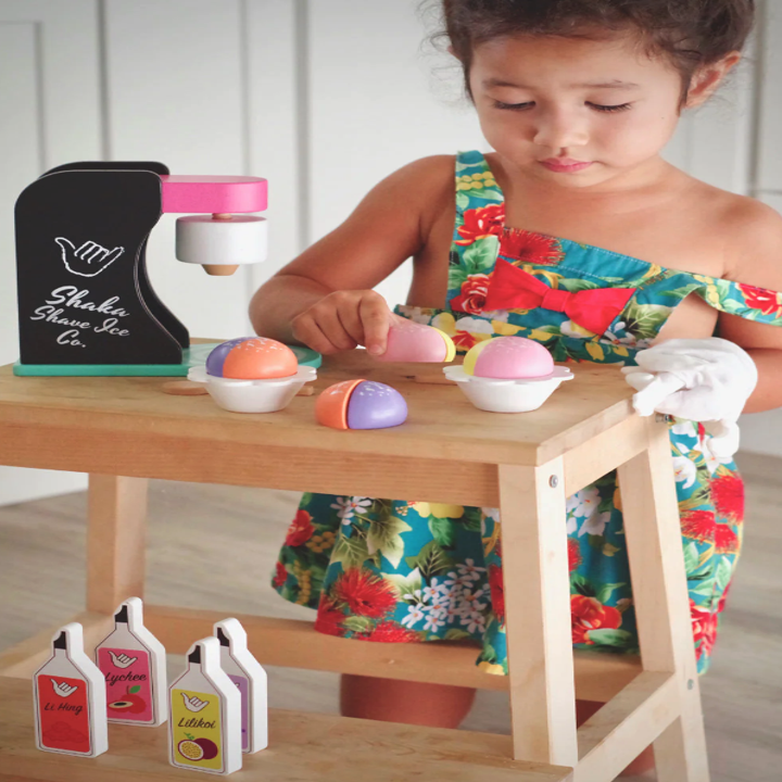 Little girl playing with a toy shaved ice machine