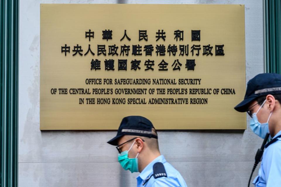 Police walk past the Office for Safeguarding National Security of the Central People's Government in the Hong Kong after its official inauguration on July 8, 2020. | Anthony WALLACE—AFP/Getty Images