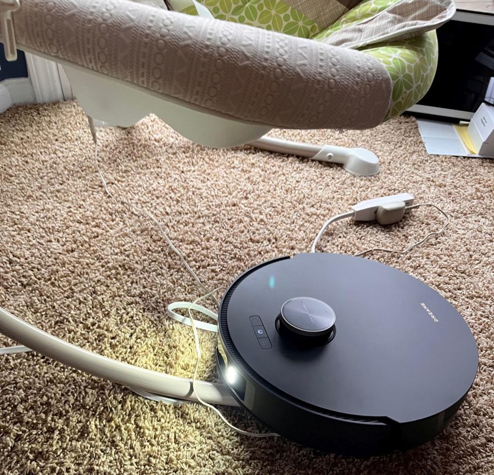 A photo of the L20 Ultra robot vacuum getting stuck on a baby swing and its power cord.