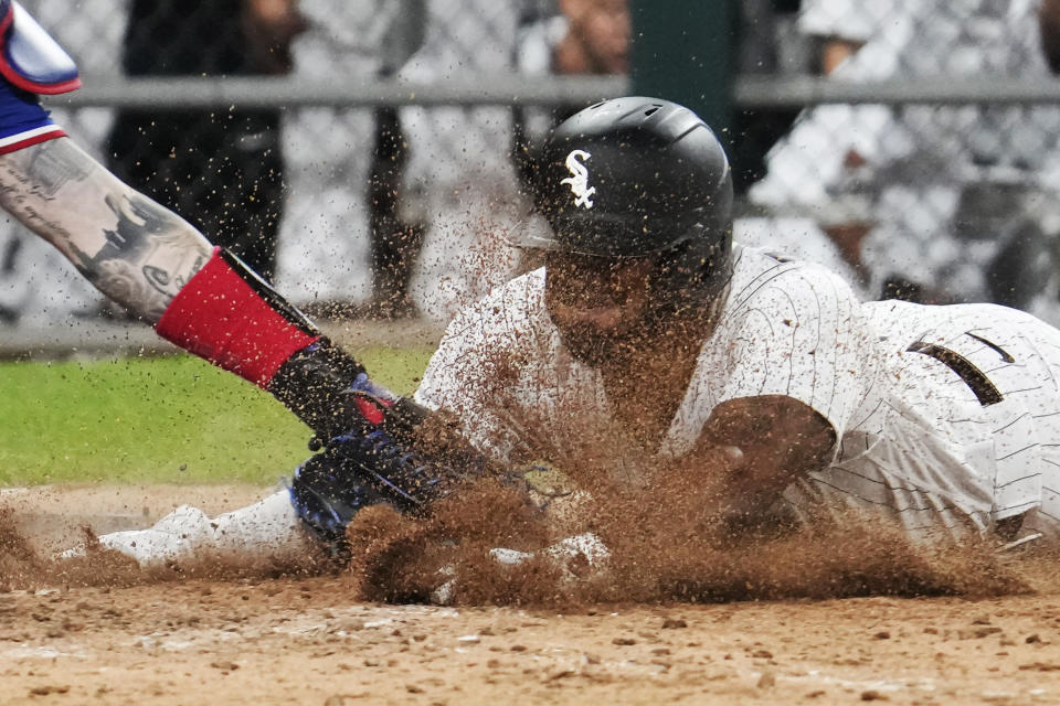 Chicago White Sox's Elvis Andrus scores against Texas Rangers catcher Jonah Heim during the eighth inning of a baseball game in Chicago, Tuesday, June 20, 2023. The White Sox won 7-6. (AP Photo/Nam Y. Huh)