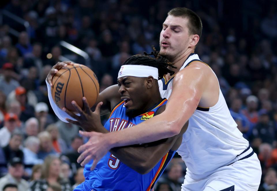 Denver center Nikola Jokic (15) defends against Oklahoma City guard Luguentz Dort (5) in the first half of the NBA basketball game between the Oklahoma City Thunder and Denver Nuggets at Paycom Center in Oklahoma City, Sunday, Oct., 29, 2023.