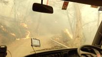 Firefighters drive through flames during evacuation after flames got too large to fight