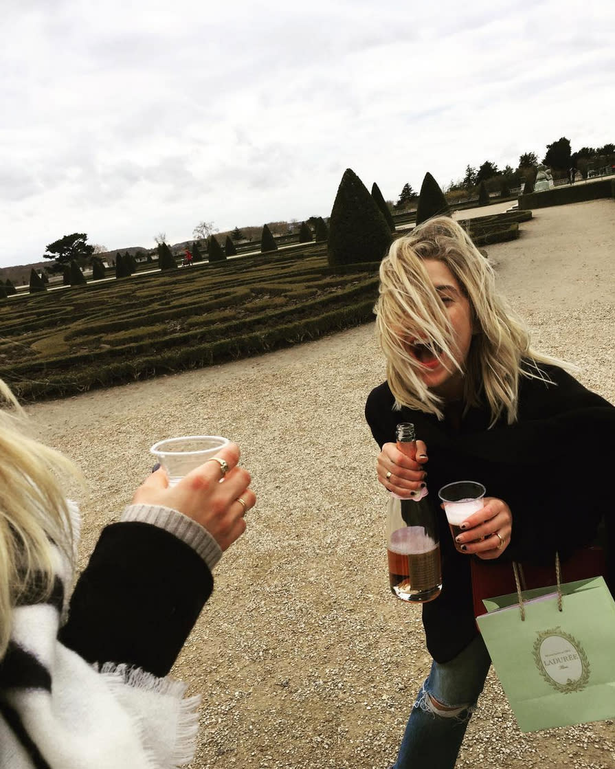 <p>Is there anything more Parisian than sipping champagne in a formal garden while toting a bag full of Laduree macarons? Ashley Benson thinks not. </p>