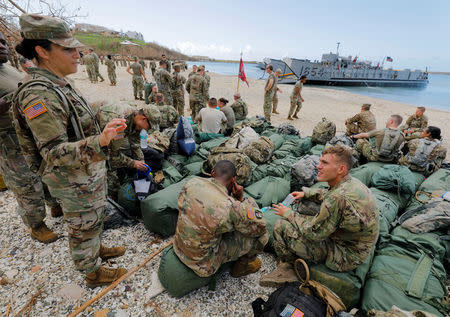 Army soldiers from the 602nd Area Support Medical Company wait with their belongings on a beach for transport on a Navy landing craft while evacuating in advance of Hurricane Maria, in Charlotte Amalie, St. Thomas, U.S. Virgin Islands September 17, 2017. REUTERS/Jonathan Drake
