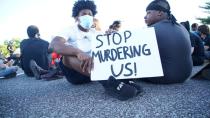 Un hombre sostiene un cartel mientras bloquea una calle durante una protesta contra la muerte del afroamericano George Floyd, en St. Louis, Missouri