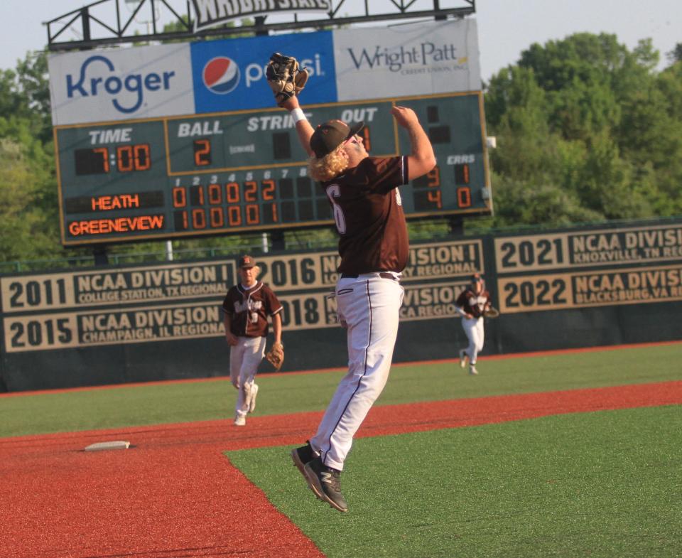 Heath's Jacob Bunn jumps up to field a high bouncer at third base during the Bulldogs' 6-2 victory over Greeneview in a Division III regional final on Friday.