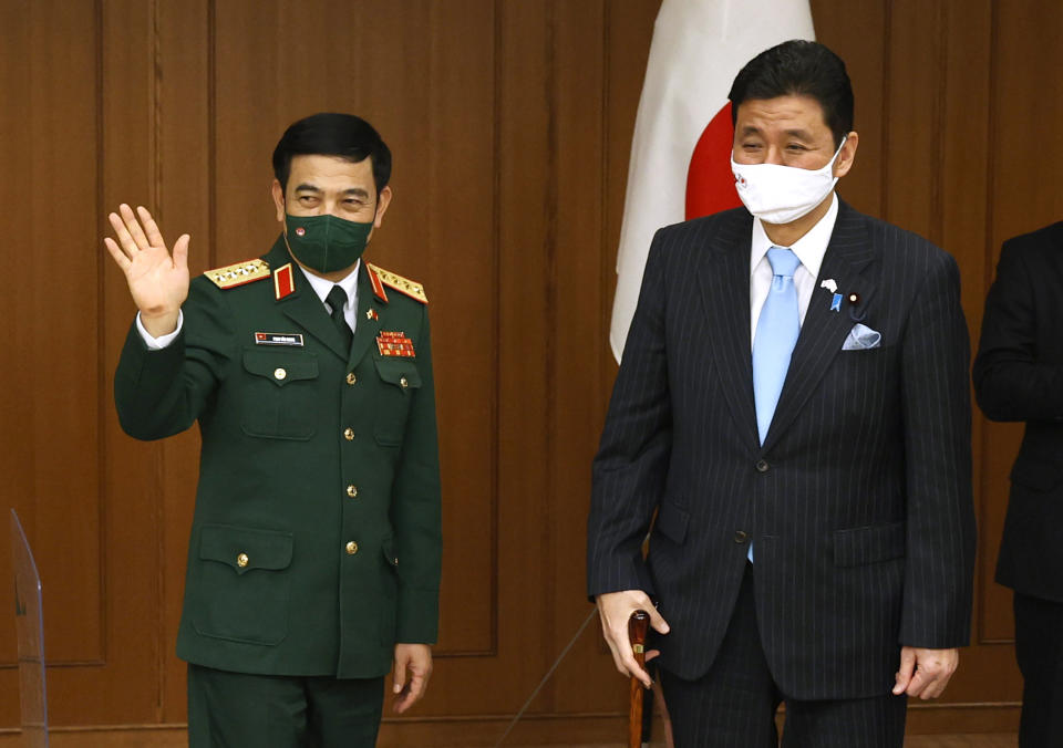 Vietnam's Defense Minister General Phan Van Giang, left, waves during a signing ceremony for the bilateral memorandums with Japan's Defense Minister Nobuo Kishi at the Defense Ministry in Tokyo, Nov. 23, 2021. (Issei Kato/Pool Photo via AP)