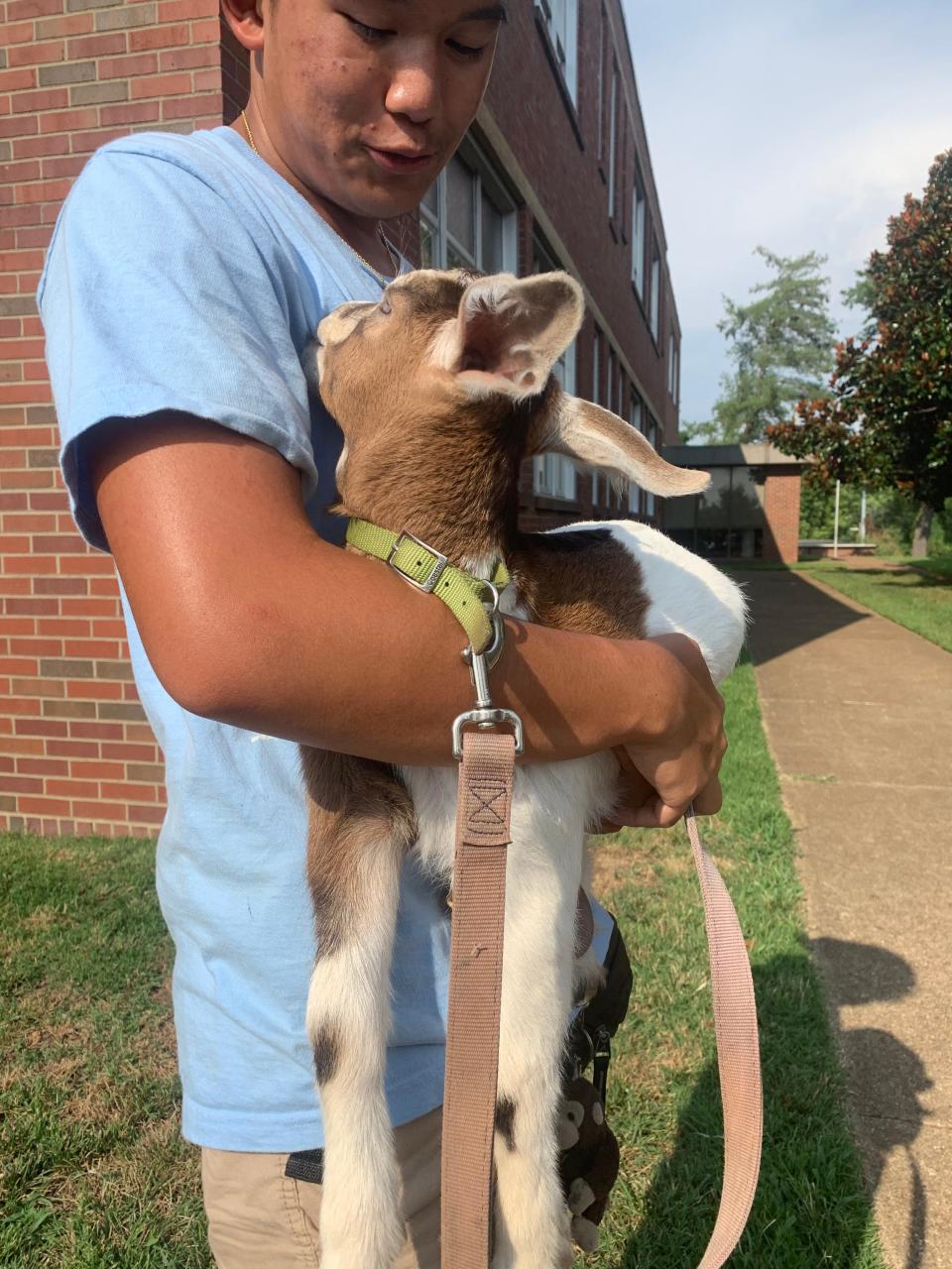 Stanley Phanthavong holds Cinnamon, a two-month-old goat, outside the Metro Nashville Public Schools administrative building ahead of a school board vote on proposed charter school Tennessee Nature Academy on Tuesday, July 12, 2022. The nature-based school would connect students to the outdoors, school officials said. Cinnamon was there to help rally support for the school.