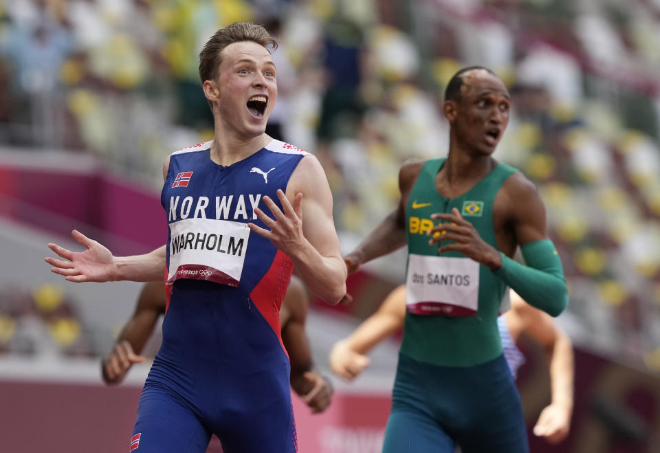 Karsten Warholm, of Norway celebrates as he wins the gold medal in the final of the men's 400-meter hurdles at the 2020 Summer Olympics, Tuesday, Aug. 3, 2021, in Tokyo, Japan. At right is Alison Dos Santos, of Brazil, who took the bronze. (AP Photo/Martin Meissner)