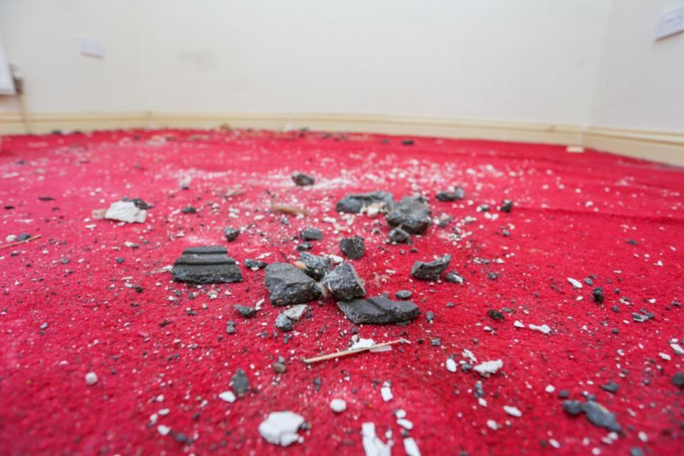 Oxford Mail: Debris on Dr George's carpet after ice fell through the roof of her home in Banbury Picture: SWNS