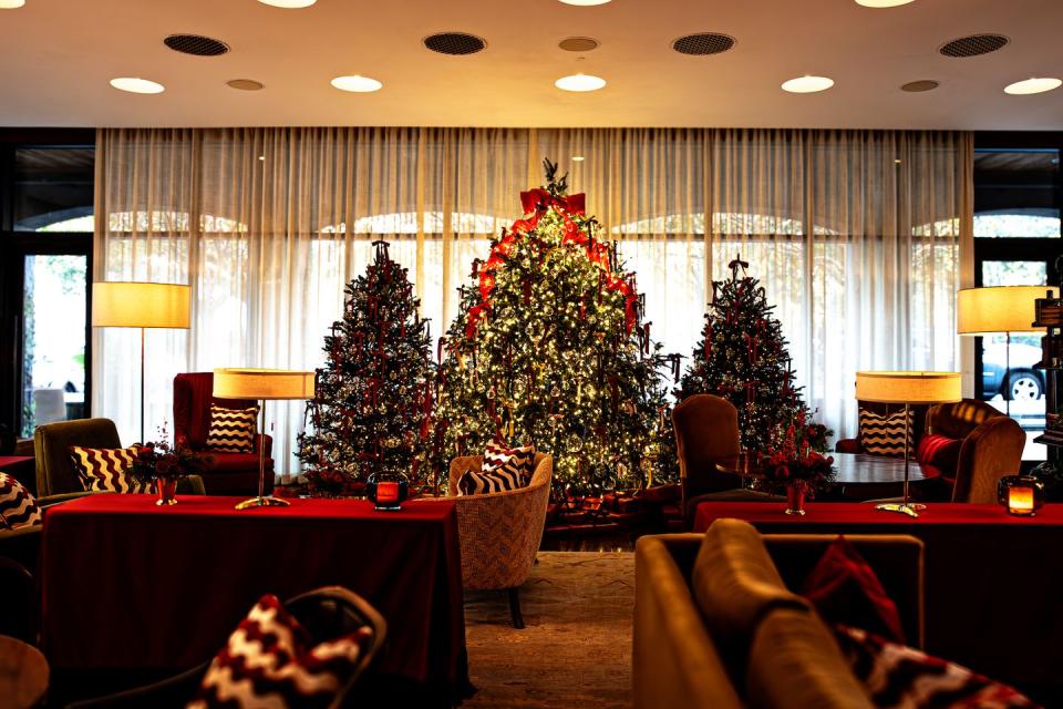 a room with a christmas tree and chairs