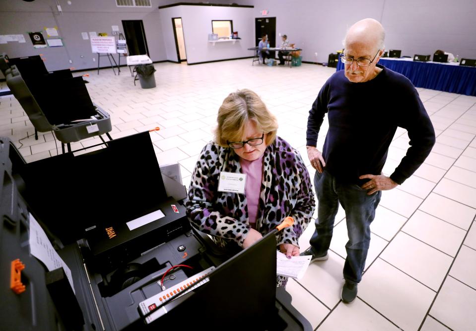 Susan Kelly prepares the voting machine at the La Vergne Multi-Purpose Building so that John Ludeman can vote during the early voting period in La Vergne, on Tuesday, Feb. 20, 2024.