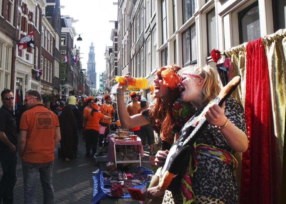 People celebrate King's Day in Amsterdam, Netherlands, Saturday, April 26, 2014. The Dutch celebrate the first ever King's Day, a national holiday held in honor of the newly installed monarch, King Willem Alexander. King's Day replaces the traditional Queen's Day. (AP Photo/Margriet Faber)