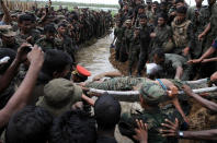 FILE- In this May 19, 2009 file photo, Sri Lankan soldiers gather as the body of Tamil rebel leader Velupillai Prabhakaran is carried on a stretcher in Mullaittivu, Sri Lanka. Tamil rebels fought a nearly three-decade separatist war accusing Sinhalese-controlled governments of systemic marginalization since independence from the British in 1948. Sri Lankan forces in 2009 crushed the rebels to end a war that claimed at least 100,000 lives according to the U.N. (AP Photo, File)