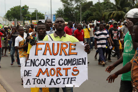 A man holds up a sign, which reads: "Faure still how many death by you", during an opposition protest calling for the immediate resignation of President Faure Gnassingbe in Lome, Togo, September 6, 2017. REUTERS/Noel Kokou Tadegnon