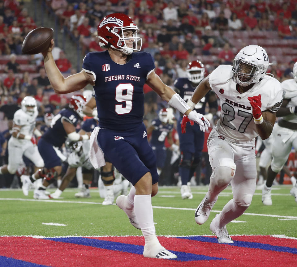 Fresno State quarterback Jake Haener avoids a sack against UNLV linebacker Austin Ajiake during the first half of an NCAA college football game in Fresno, Calif., Friday, Sept. 24, 2021. (AP Photo/Gary Kazanjian)