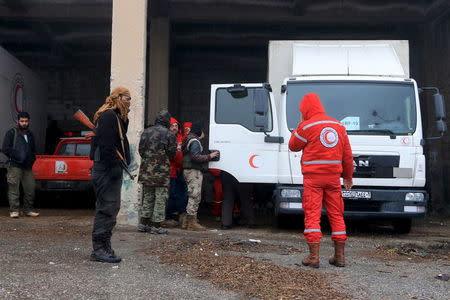 Rebel fighters inspect Red Crescent vehicles on their way to al Foua and Kefraya, in Idlib province, Syria January 11, 2016. REUTERS/Ammar Abdullah