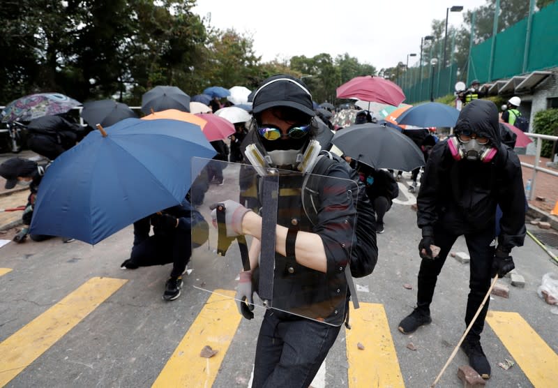 FILE PHOTO: Demonstrators stand with shields and umbrellas during an anti-government protest at the Chinese University of Hong Kong in Sha Tin, Hong Kong, China