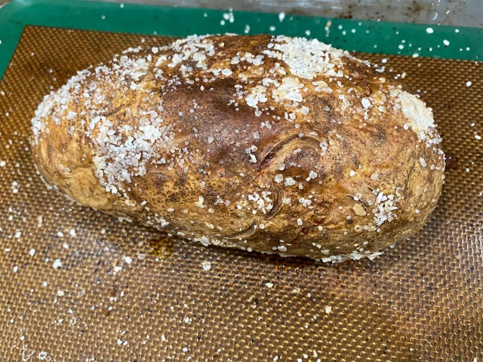 baked potato covered in salt on a baking tray lined with a silicone mat