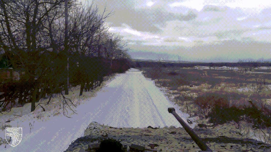 A moving image showing a BMP-2 armored vehicle driving down a snowy road.