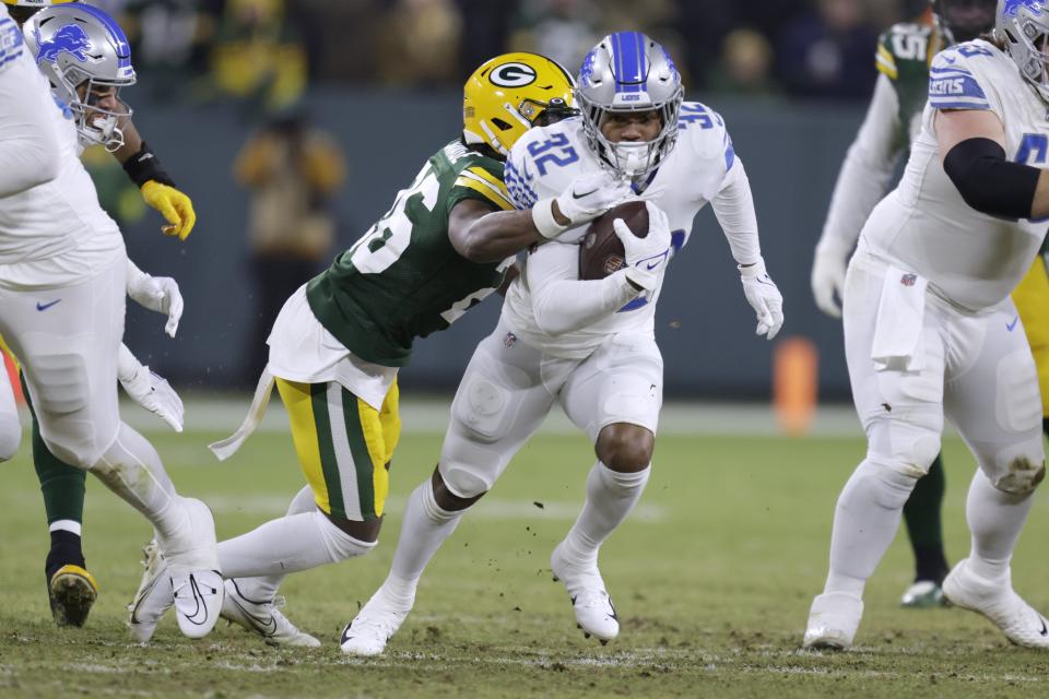 Lions running back D'Andre Swift runs with the ball as Packers safety Darnell Savage defends during the first half on Sunday, Jan. 8, 2023, in Green Bay, Wisconsin.