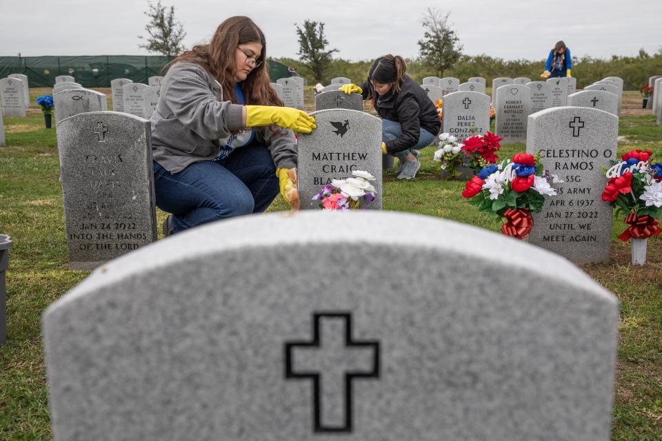 Kari Carrasco, left, and Katelyn Morin use sponges to to wipe headstone with soapy water at the Coastal Bend Veteran's Cemetery on Tuesday, Nov. 28, 2023, in Corpus Christi, Texas. Carrasco and Morin volunteered to clean headstones with TAMUCC staff.