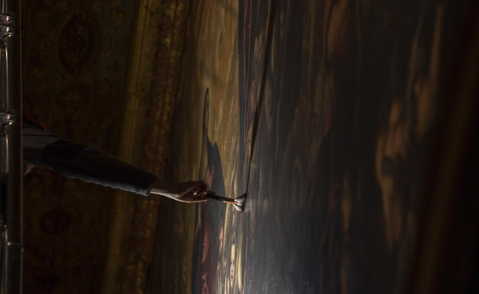 Restorer Alberto Marcon inspects the 7,45x24,65-meter oil on canvas 'Il Paradiso' completed in 1592 by Venetian painters Jacopo Robusti, also known as Tintoretto, and his son Domenico in the Maggior Consiglio Hall inside Palazzo Ducale in Venice, northern Italy, Wednesday, Dec. 6, 2022. The Doge's Palace, the heart of the political life of the Venetian Republic for centuries, is undergoing a major reconnaissance of its conservation status by the Fondazione Musei Civici of the municipality of Venice that includes the urgent restoration of its paintings and infrastructures, which is expected to be completed in the summer of 2023. (AP Photo/Domenico Stinellis)