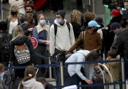 Holiday travelers crowd the ticketing area of terminal one Wednesday, Nov. 25, 2020 at MSP in Minneapolis. Millions of Americans took to the skies and the highways ahead of Thanksgiving at the risk of pouring gasoline on the coronavirus fire, disregarding increasingly dire warnings that they stay home and limit their holiday gatherings to members of their own household. (David Joles/Star Tribune via AP)