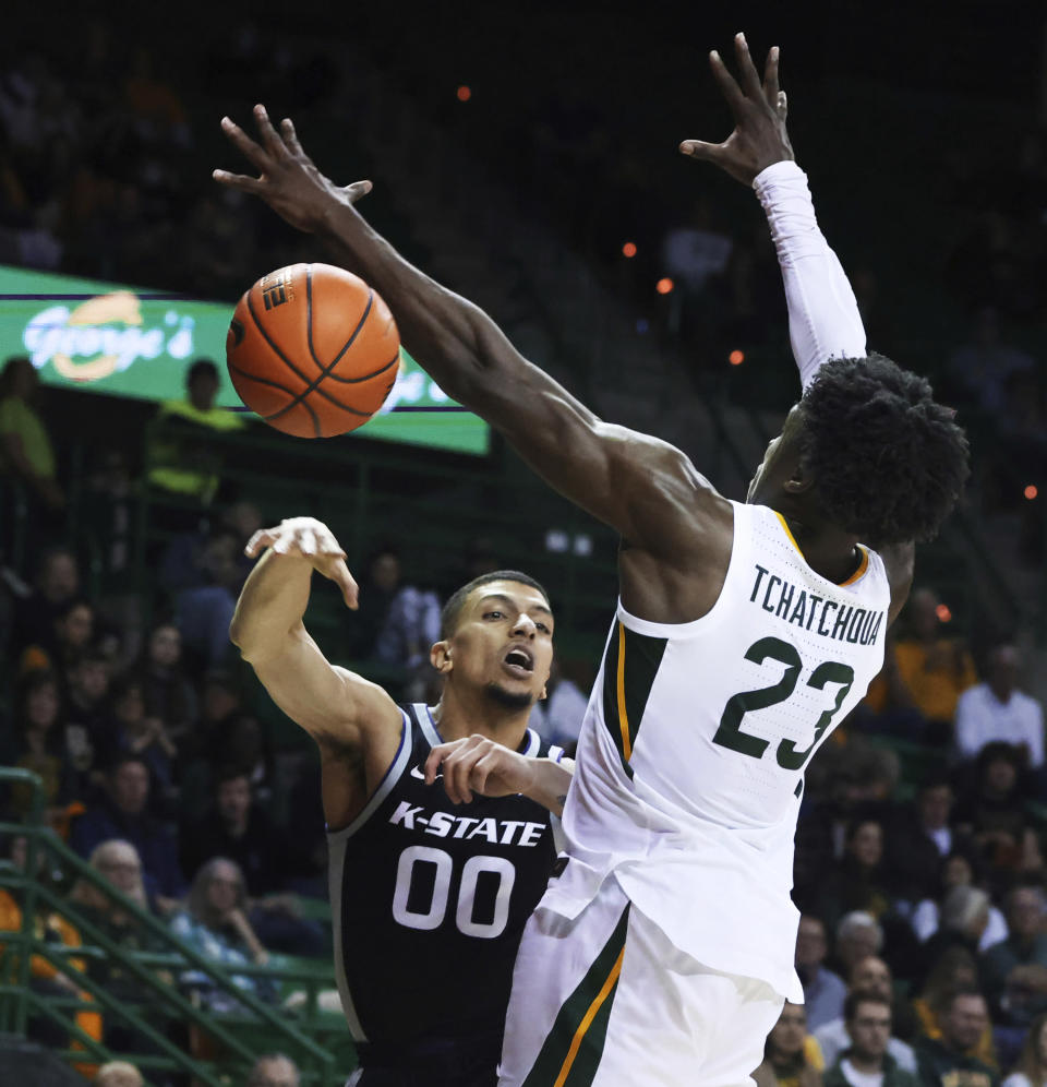 Kansas State guard Mike McGuirl, left, makes a pass around Baylor forward Jonathan Tchamwa Tchatchoua, right, in the first half of an NCAA college basketball game, Tuesday, Jan. 25, 2022, in Waco, Texas. (Rod Aydelotte/Waco Tribune Herald, via AP)