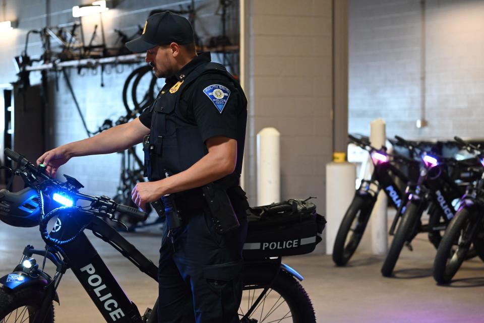 South Bend Police Department Captain Kyle Dombrowski demonstrates the use of headlights and police lights on the department's new e-bikes on May 9, 2024, in the department's garage at 701 W. Sample St.