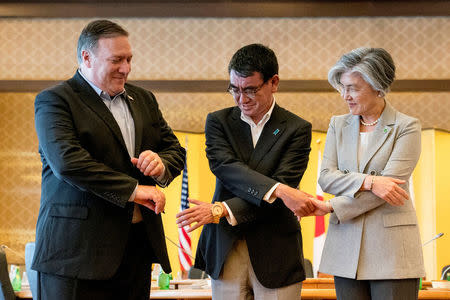 U.S. Secretary of State Mike Pompeo, Japan's Foreign Minister Taro Kono and South Korea's Foreign Minister Kang Kyung Wha shake hands for members of the media as they meet in Tokyo, Japan, July 8, 2018. Andrew Harnik/Pool via Reuters