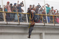 A Honduran migrant, part of a caravan trying to reach the U.S., climbs down from the bridge that connects Mexico and Guatemala to avoid the border checkpoint in Ciudad Hidalgo, Mexico, October 19, 2018. REUTERS/Edgard Garrido