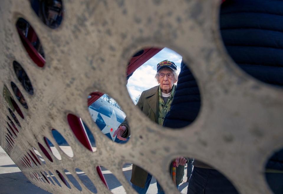 Russell Phipps, 101, of Hopkinton, is shown framed through a wing of an SBD Dauntless aircraft, the primary carrier-based dive bomber used by the U.S. Navy during World War II, Dec. 29, 2022. Phipps was visiting the American Heritage Museum in Hudson.