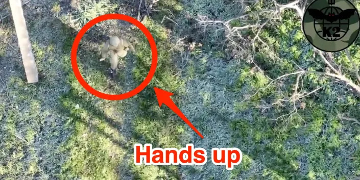 A still from aerial footage shared by the Ukrainian Ministry of Defense, showing a uniformed figure walking with hands up in apparent surrender. Insider marked up the image to highlight the figure and add text saying: 