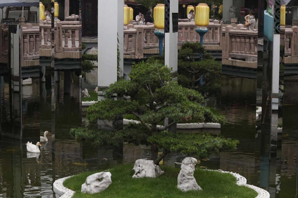 Visitors to the Yu Garden Mall are reflected on mirrors Thursday, June 2, 2022, in Shanghai. Traffic, pedestrians and joggers reappeared on the streets of Shanghai on Wednesday as China's largest city began returning to normalcy amid the easing of a strict two-month COVID-19 lockdown that has drawn unusual protests over its heavy-handed implementation. (AP Photo/Ng Han Guan)