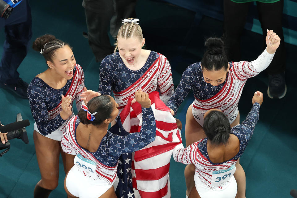 Team USA celebrates their victory in the team gymnastics competition. 