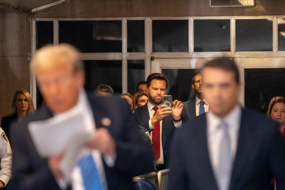 US Senator J.D. Vance (R-OH) takes pictures as former President Donald Trump speaks to reporters before departing Manhattan criminal court on May 13, 2024, in New York where he is on trial for allegedly covering up hush money payments linked to extramarital affairs.