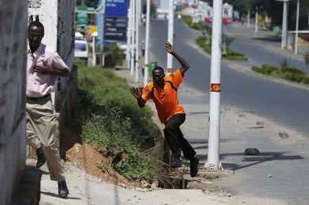 Men run for cover after they hear gunfire in a street in Bujumbura, Burundi May 14, 2015. REUTERS/Goran Tomasevic