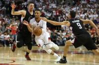 Portland Trail Blazers guard Damian Lillard (0) dribbles in between Los Angeles Clippers guard Austin Rivers (25) and guard Pablo Prigioni (9) in game four of the first round of the NBA Playoffs at Moda Center at the Rose Quarter. Mandatory Credit: Jaime Valdez-USA TODAY Sports