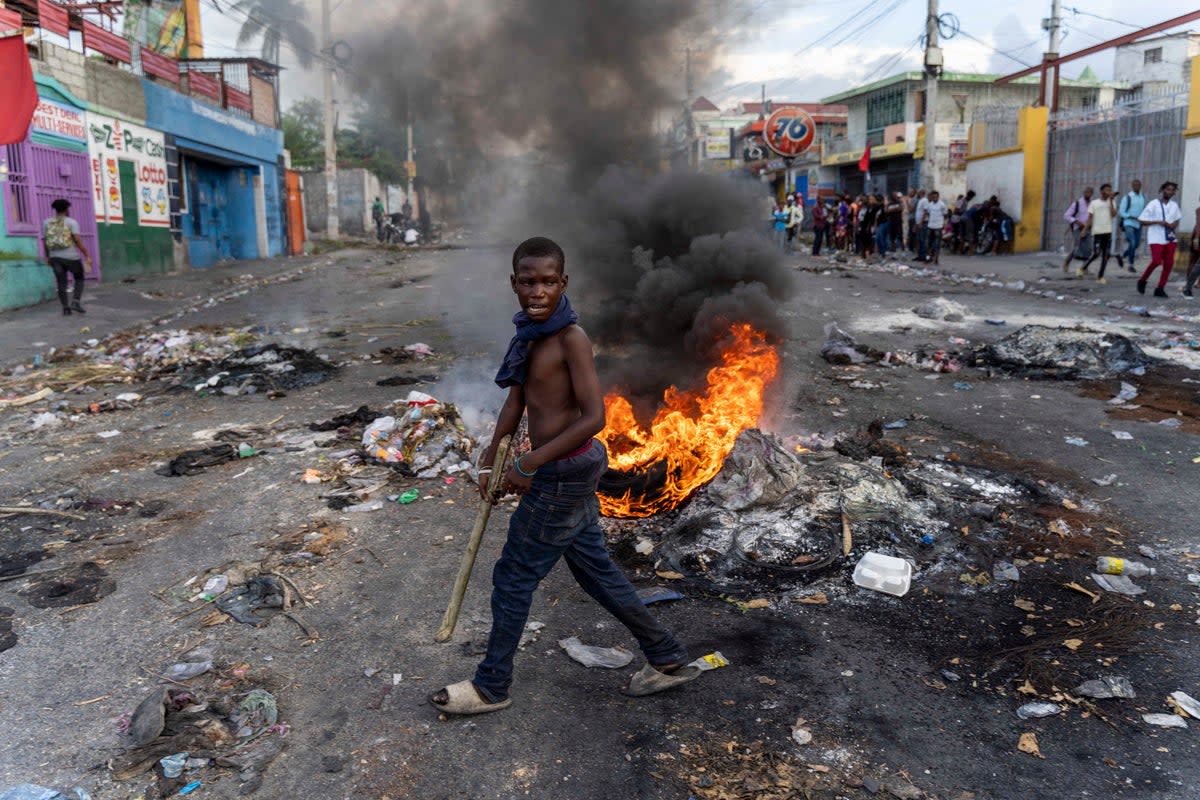 A mans walks past a burning barricade during a protest Mr Henry calling for his resignation, in Port-au-Prince, Haiti (AFP via Getty Images)