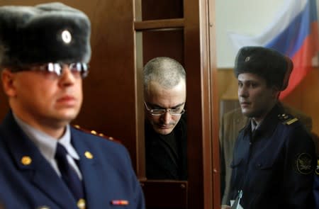 FILE PHOTO: Russian oil tycoon Mikhail Khodorkovsky stands before a court session starts in a court in Moscow