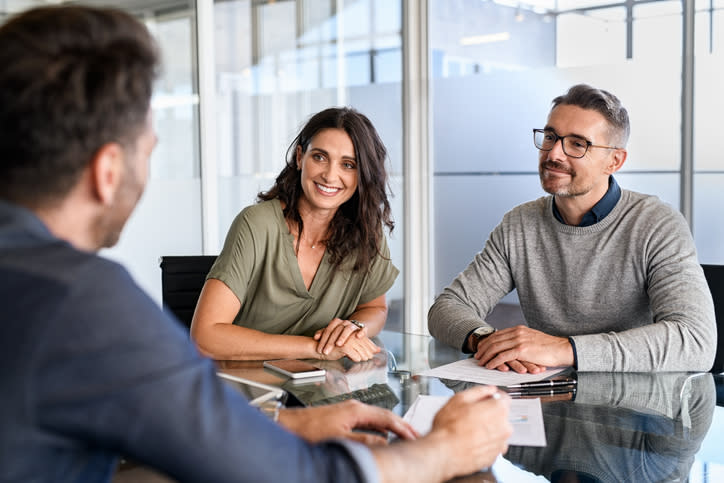 A couple meeting with a financial advisor to discuss investment options for their Roth IRA.